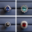 Four diamond-encrusted gemstone rings on a blue background